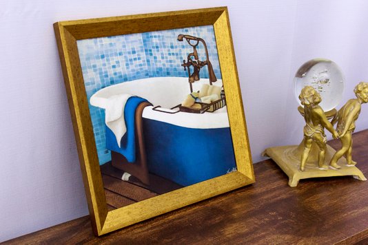 Quadro Decorativo com Moldura Dourada Banheira Branca e Azul com Toalhas Coloridas 30x30cm