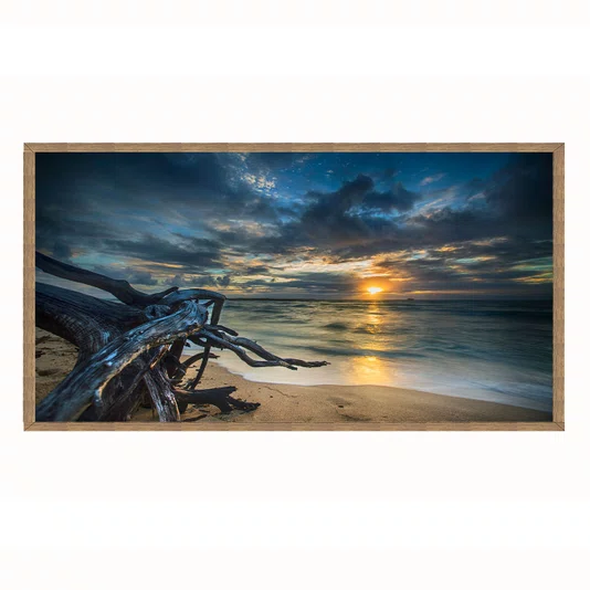 Quadro Paisagem de Praia ao Pôr do Sol com Tronco na Areia e Reflexo no Mar